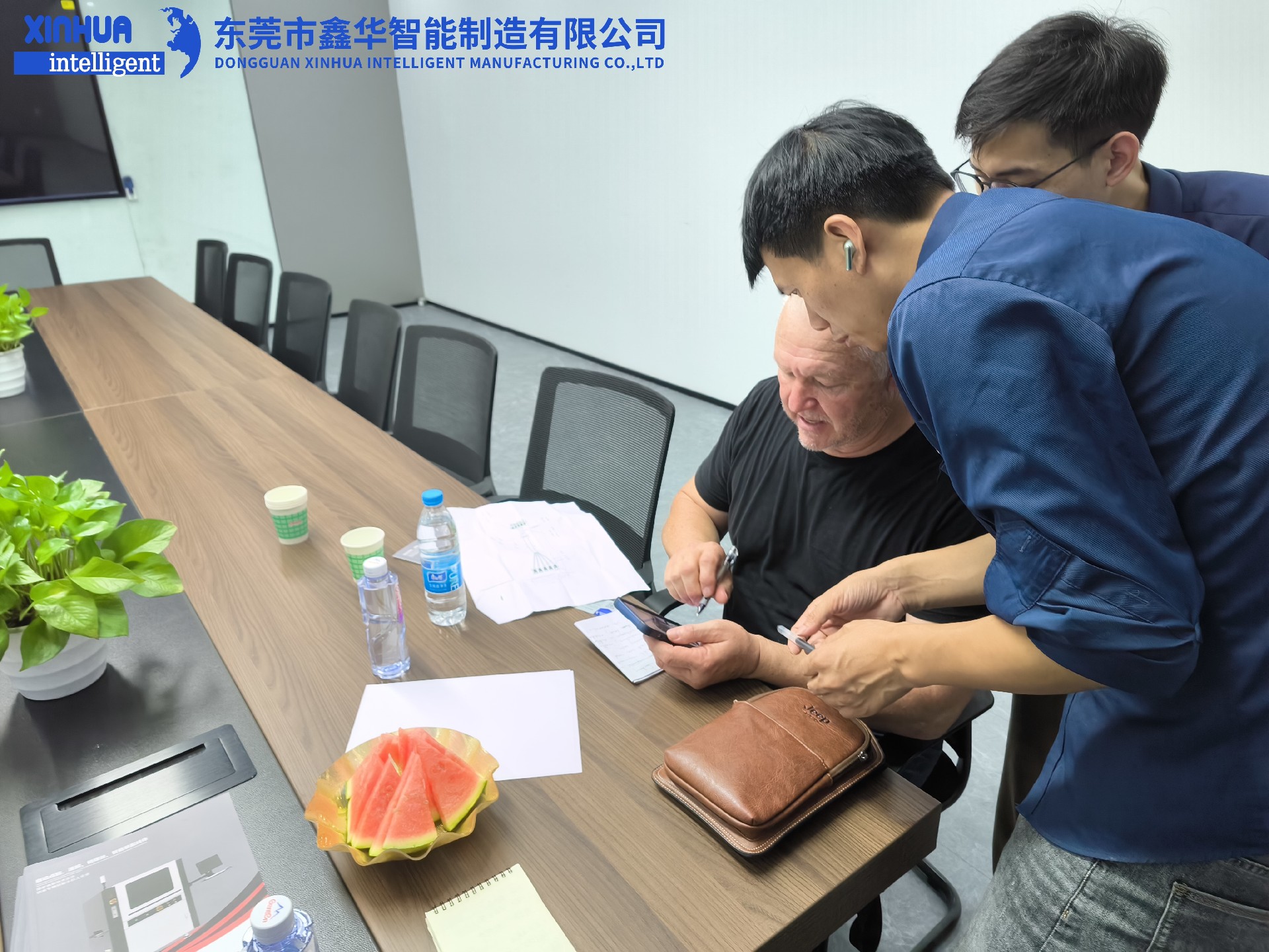 業(yè)務(wù)部2位男同事在給美國客戶耐心介紹自動鎖螺絲機性能